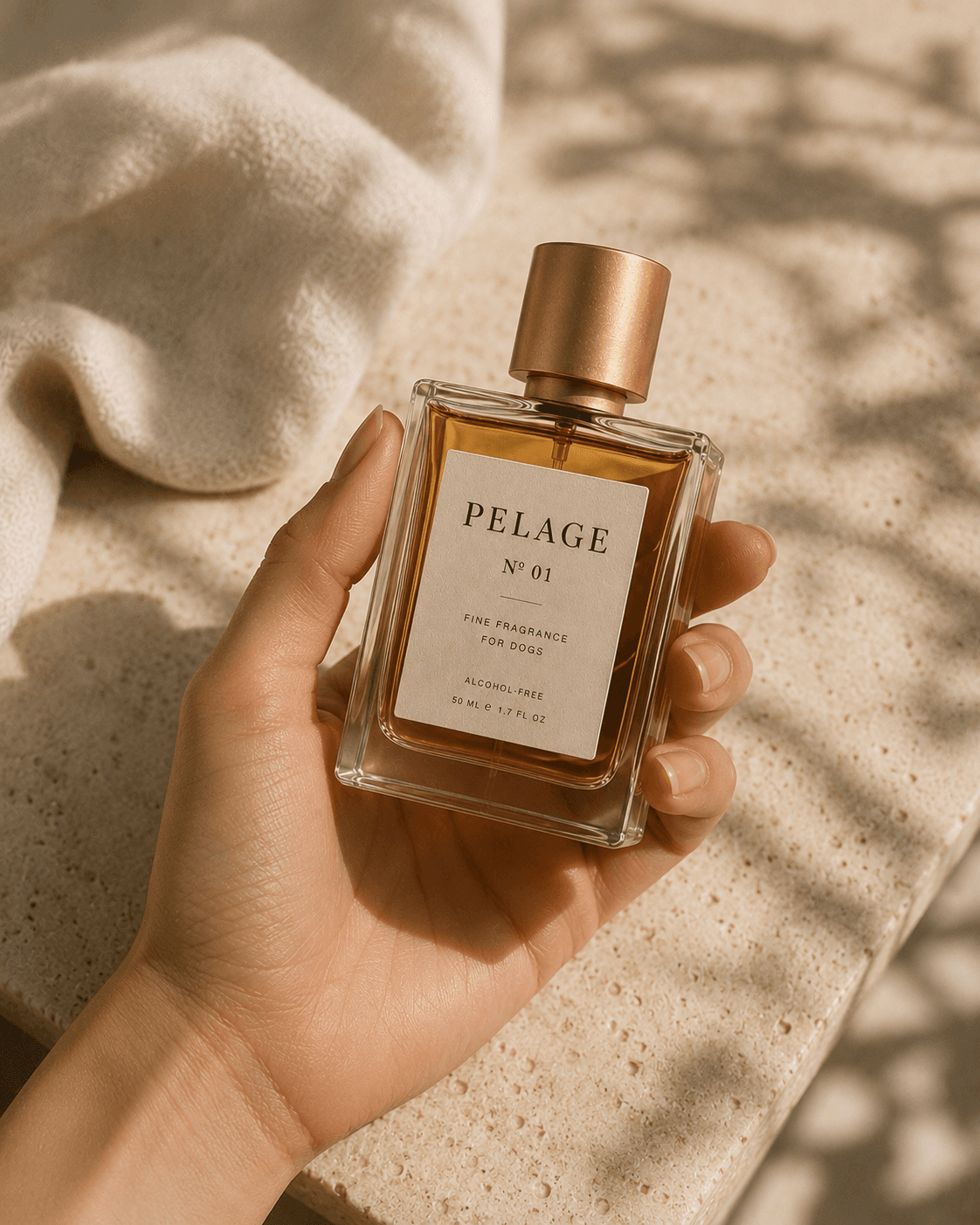Hand holding Pelage Nº 01 bottle, travertine surface, natural light